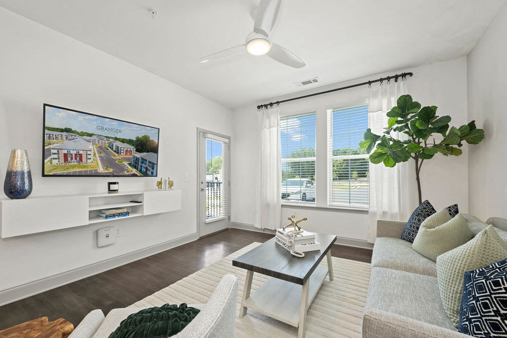 a living room with a couch coffee table and a tv on the wall