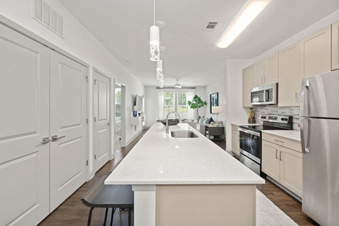 a large white kitchen with white cabinets and stainless steel appliances