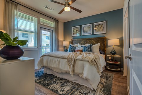 A bedroom with a bed, a ceiling fan, and a rug.