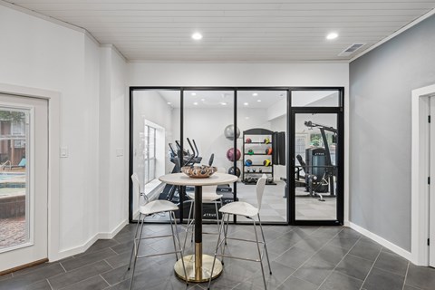 A modern dining room with a glass table and chairs.