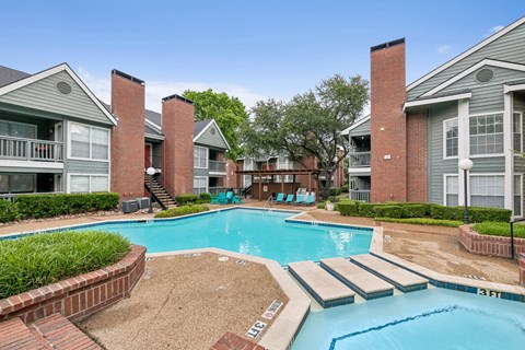 A swimming pool surrounded by brick buildings.