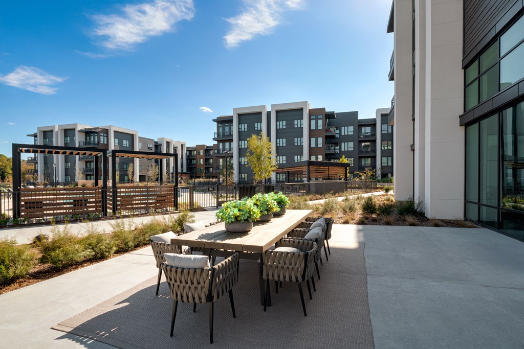 A modern outdoor dining area with a table set for six.