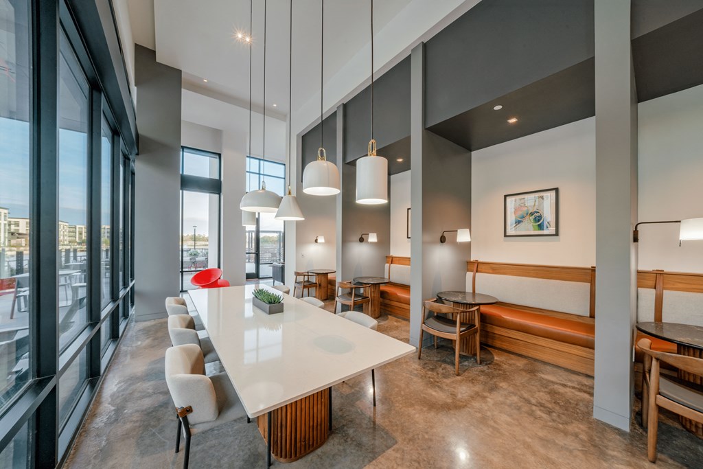 A modern dining area with a long table and chairs.