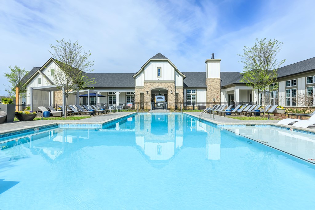 A large swimming pool in front of a building with a white facade.