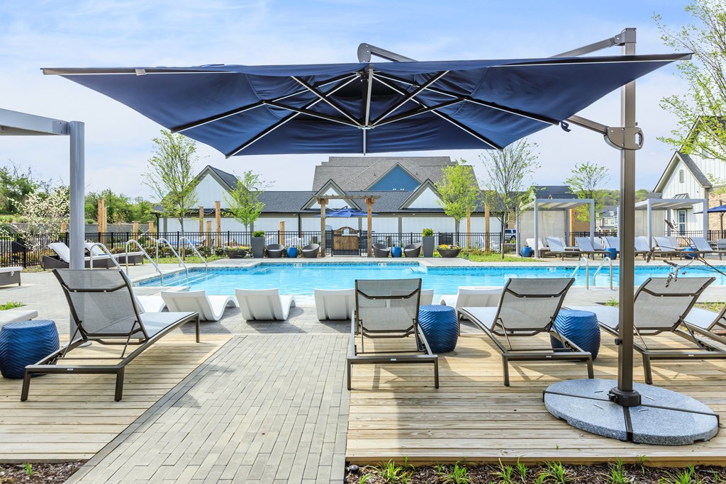 A pool area with a canopy and lounge chairs.
