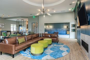 A living room with a brown couch and a blue and white rug.