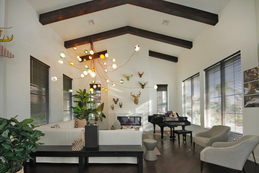 A living room with a piano and a chandelier.