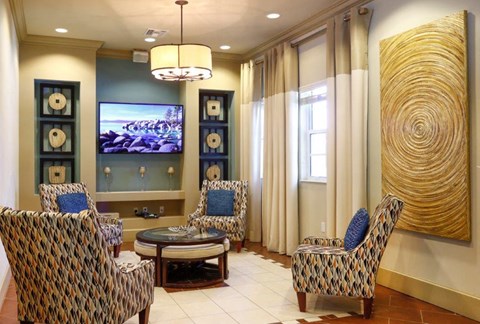 a living room with chairs and a television