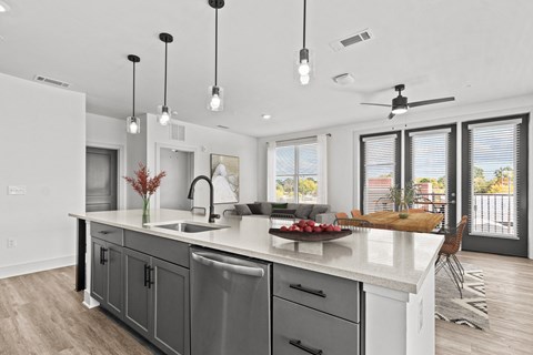 an open kitchen and living room with a large island and a sink