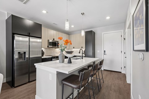 A modern kitchen with a white island and stainless steel appliances.