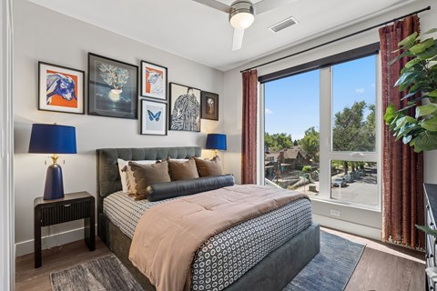 A bedroom with a large bed and a view of the outdoors through the window.