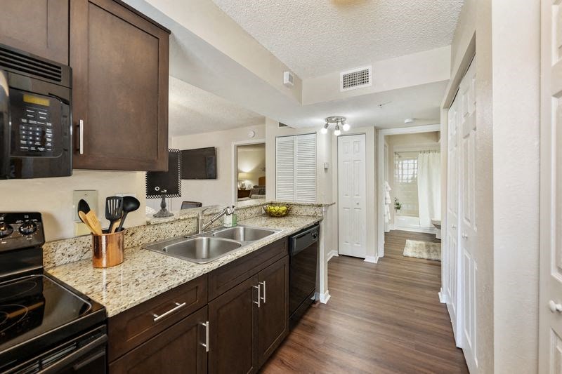 a kitchen with a sink and a stove and a hallway