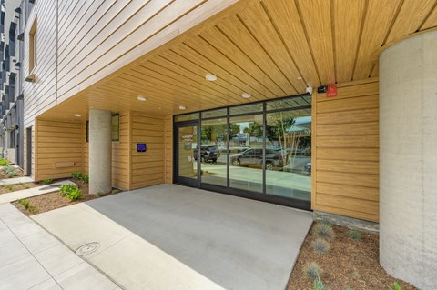 A modern building with a wooden exterior and glass doors.