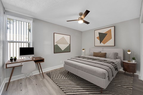 an expansive bedroom with a bed and a desk with a computer