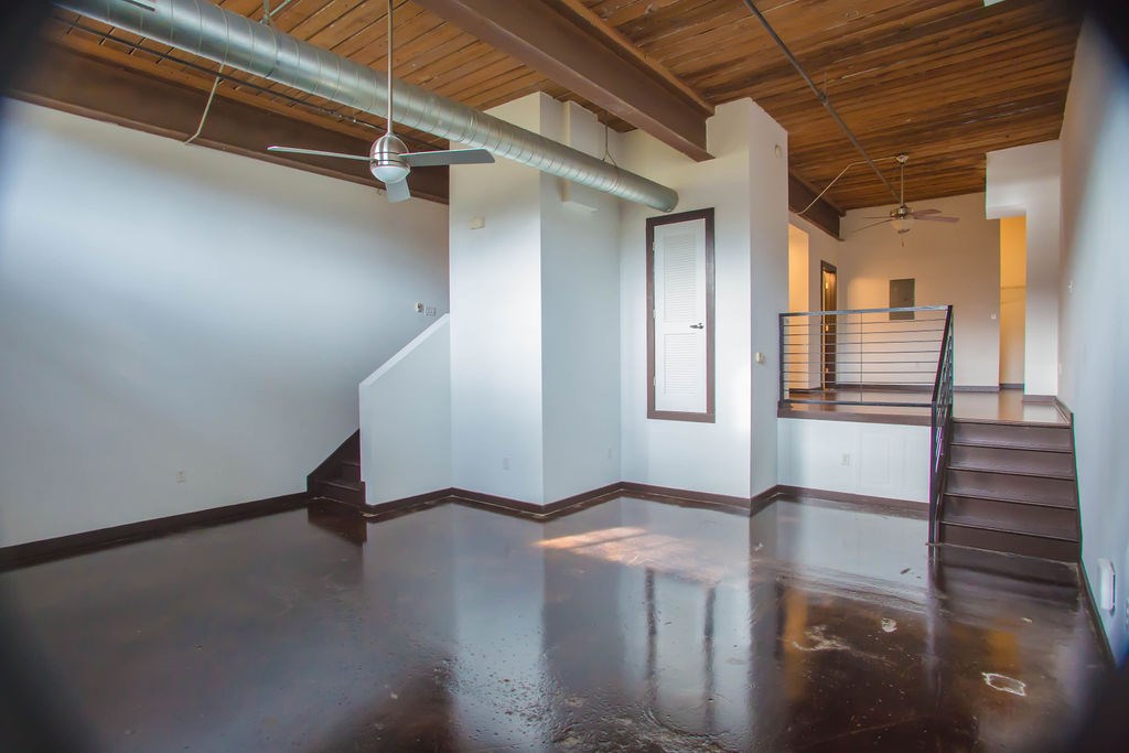 A room with a wooden ceiling and a metal pipe running across it.
