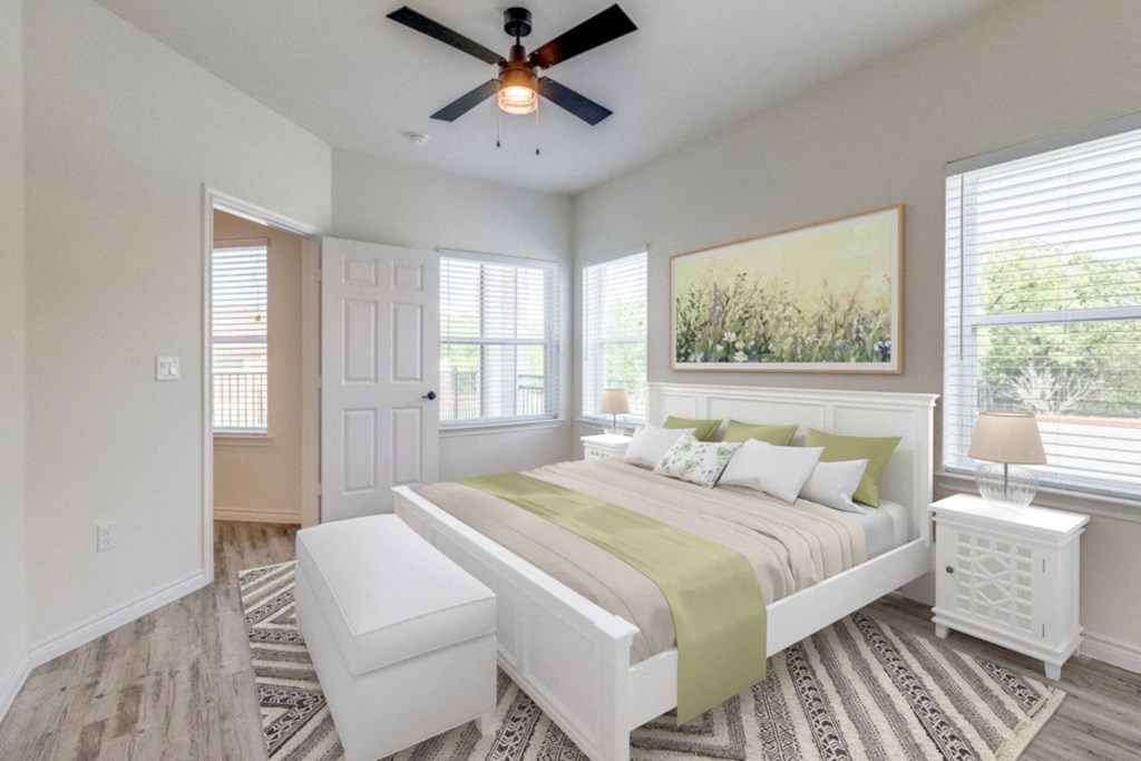 a bedroom with a large bed and a ceiling fan