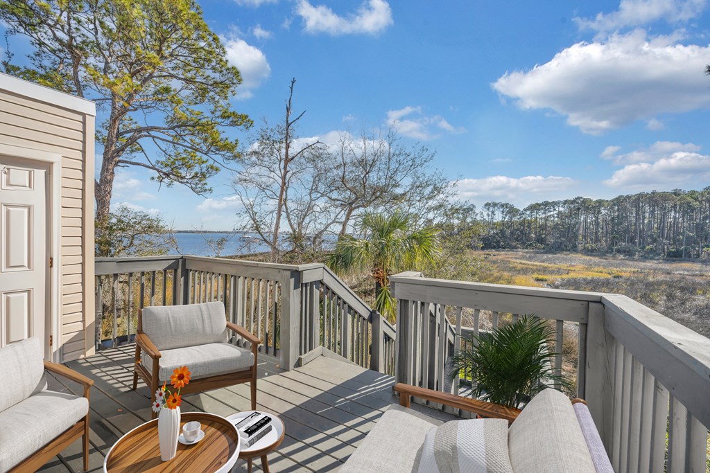 a deck with two chairs and a table overlooking a body of water