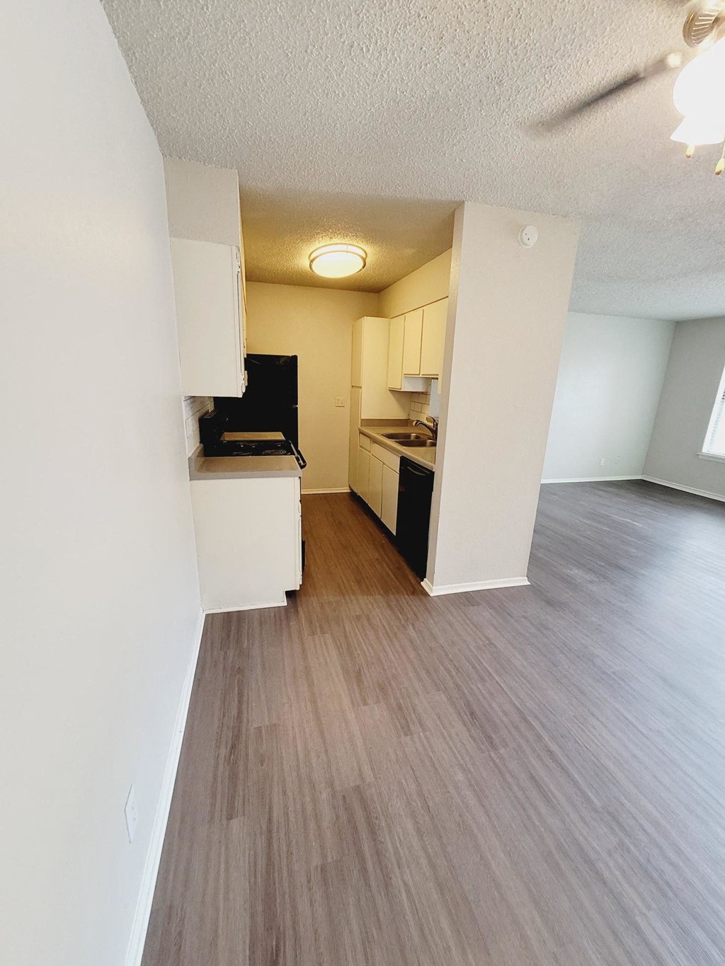an open kitchen and living room with a wood floor
