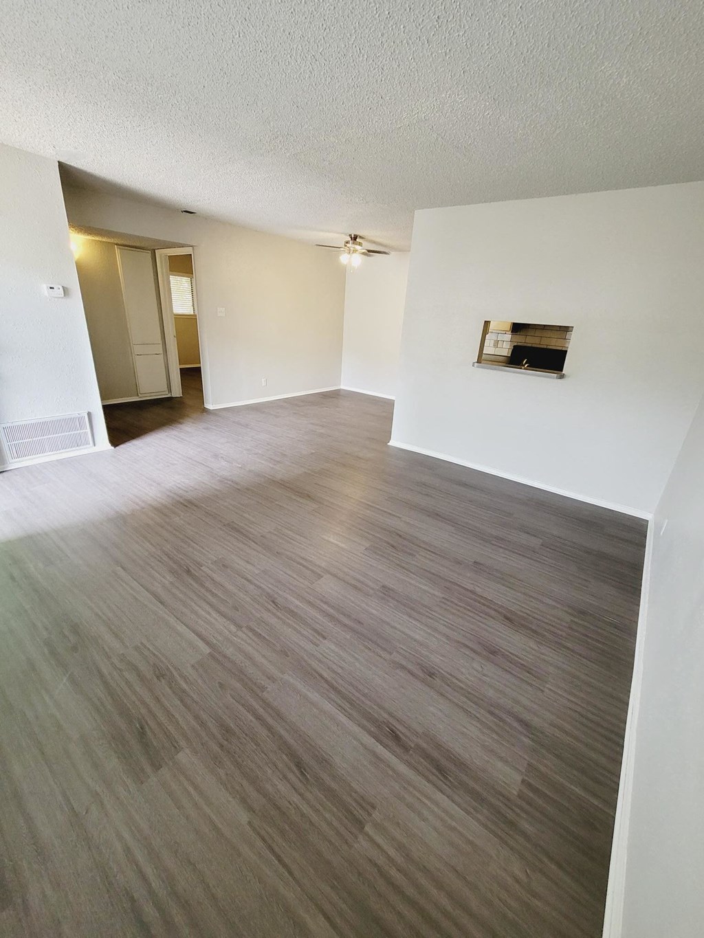 an empty living room and dining room with wood flooring