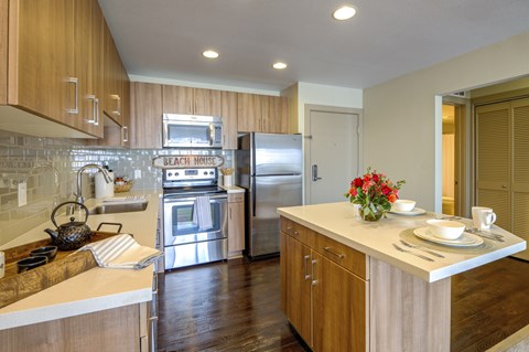 A kitchen with wooden cabinets and a white counter top.