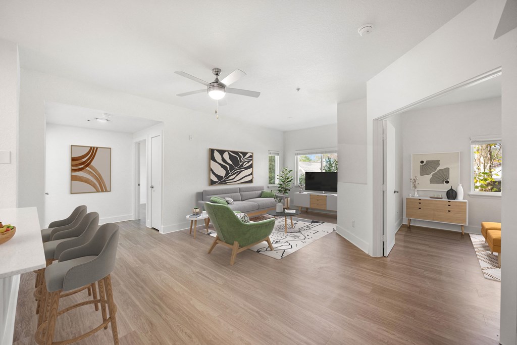 a living room with white walls and a ceiling fan