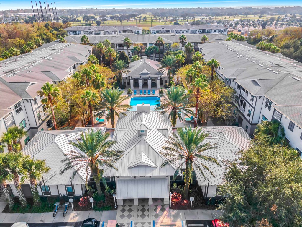 arial view of the courtyard of a building with palm trees and a pool
