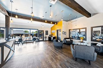 A modern living room with grey chairs and a wooden floor.