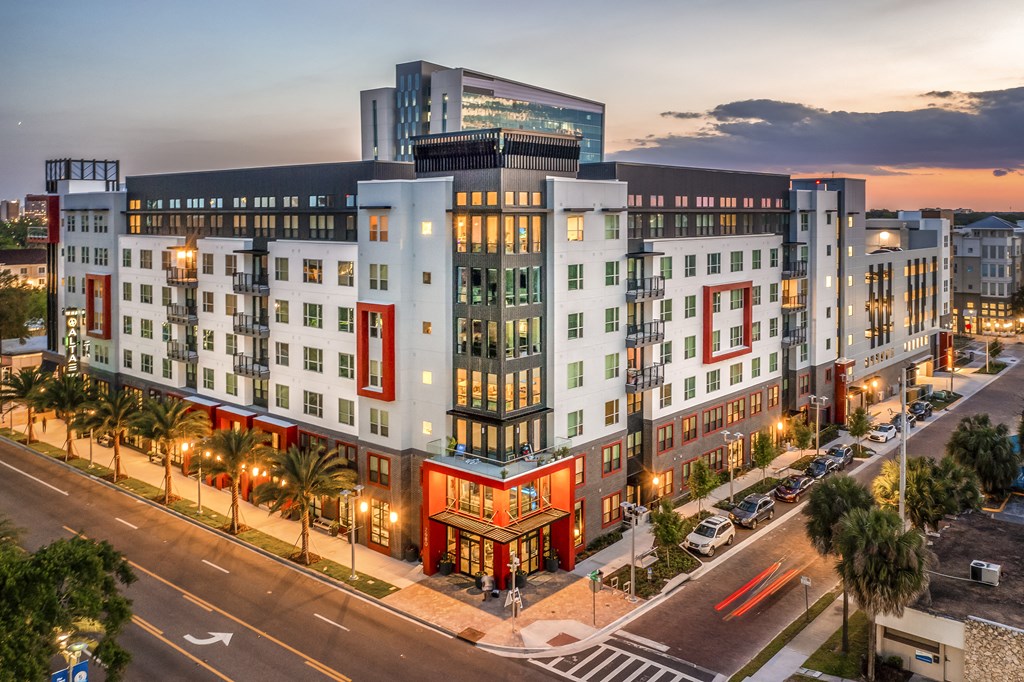 an aerial view of a large building on a city street at dusk