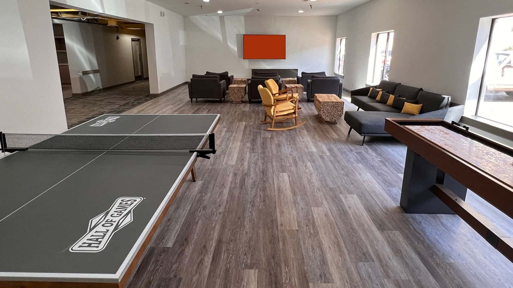 an open living room with a ping pong table and couches