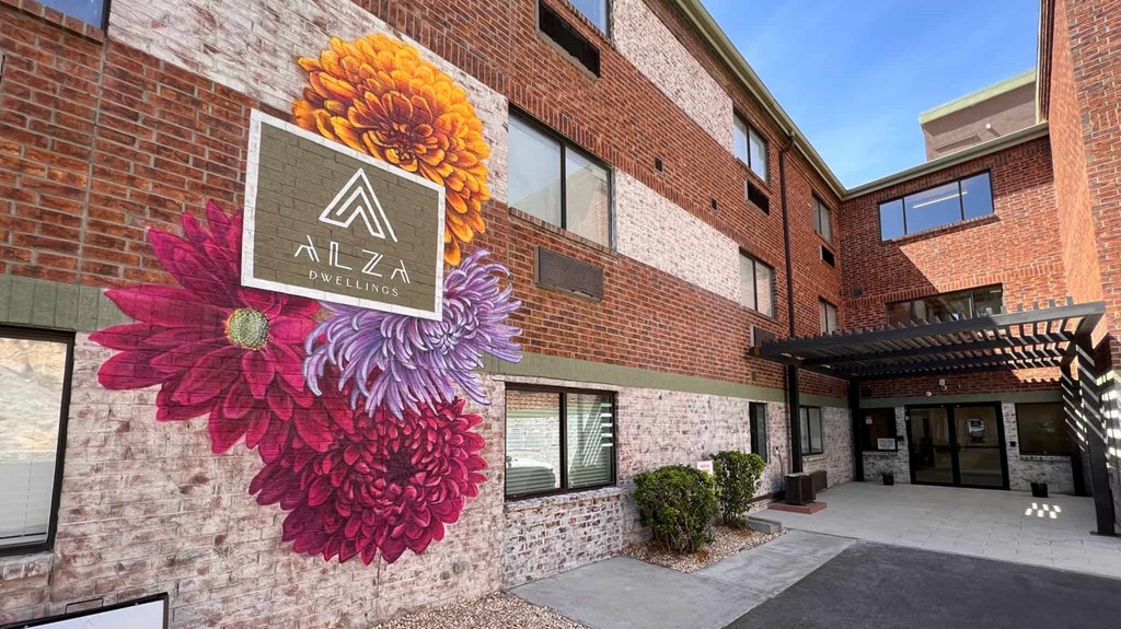 a mural of three flowers on the side of a building