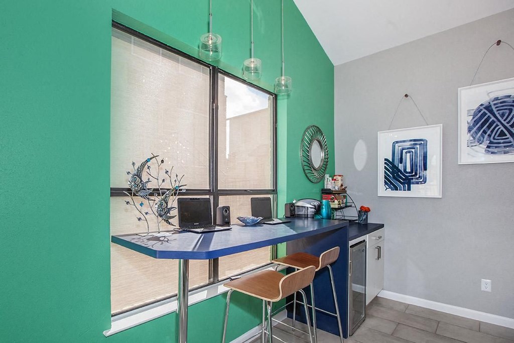 a green walled room with a desk and a window