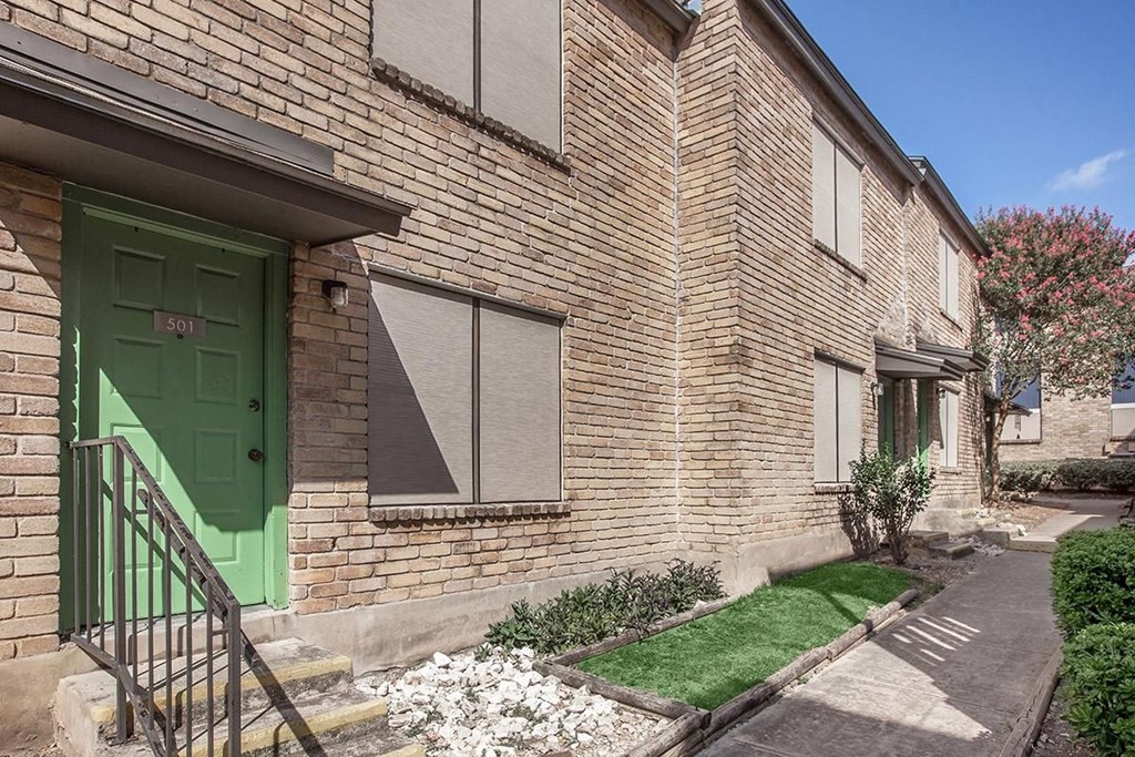 the front of a brick house with a green door