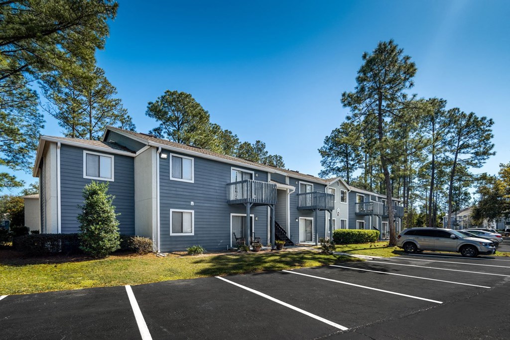 A row of townhouses with a car parked in front.