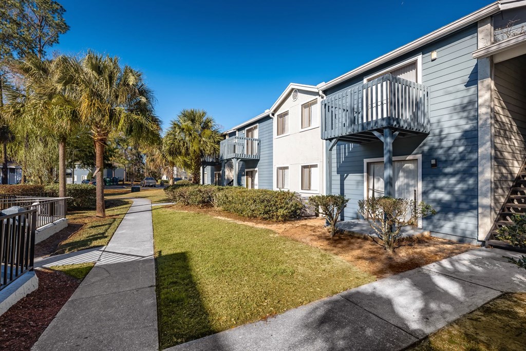 A sunny day at a residential area with apartment buildings and palm trees.