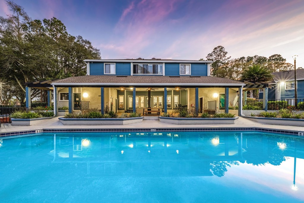 A blue house with a pool in front.