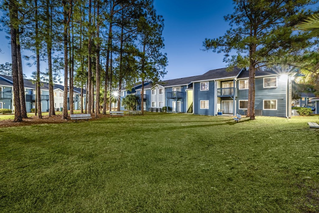 A grassy area in front of apartment buildings.