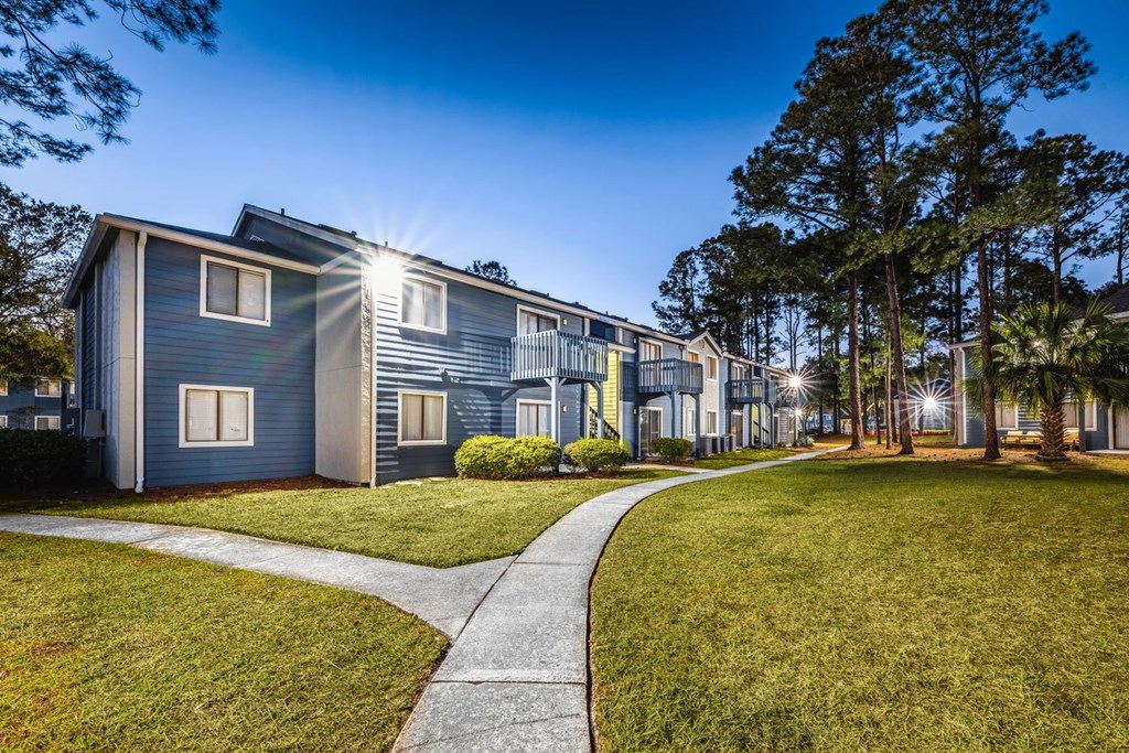 A row of houses with a sidewalk in front.