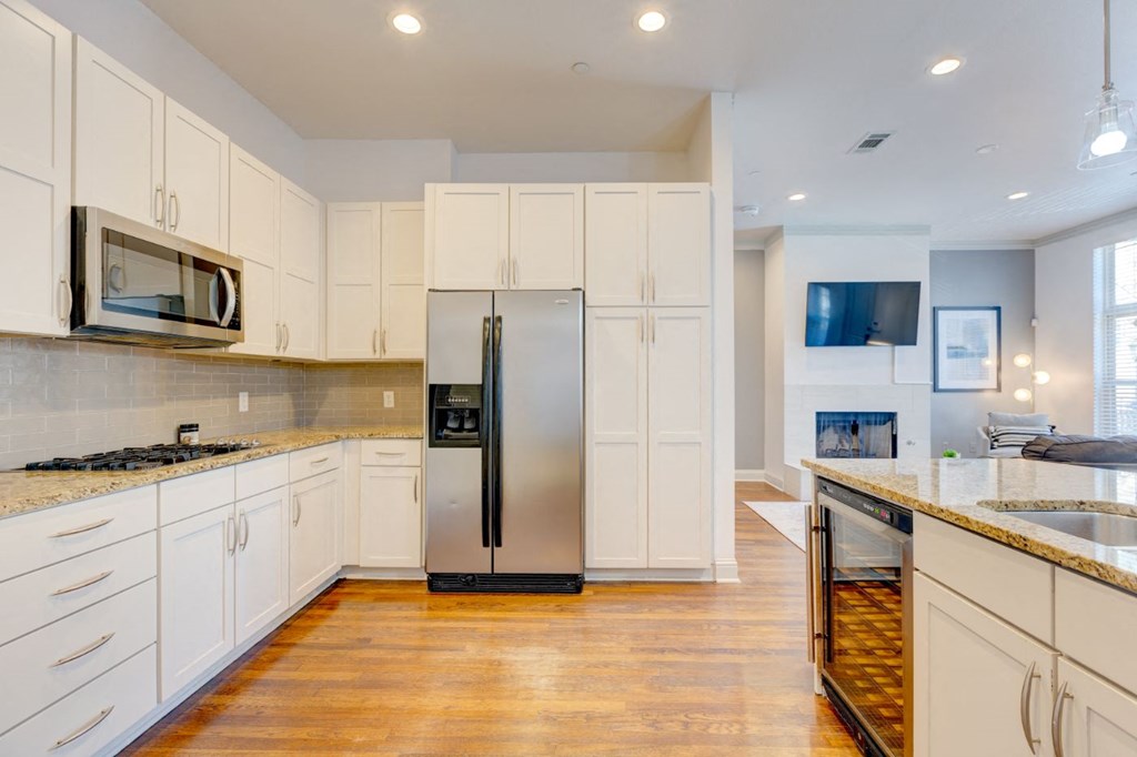 a kitchen with white cabinets and a stainless steel refrigerator