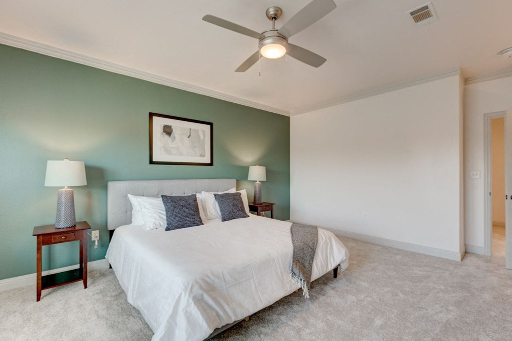 a bedroom with a bed and a ceiling fan