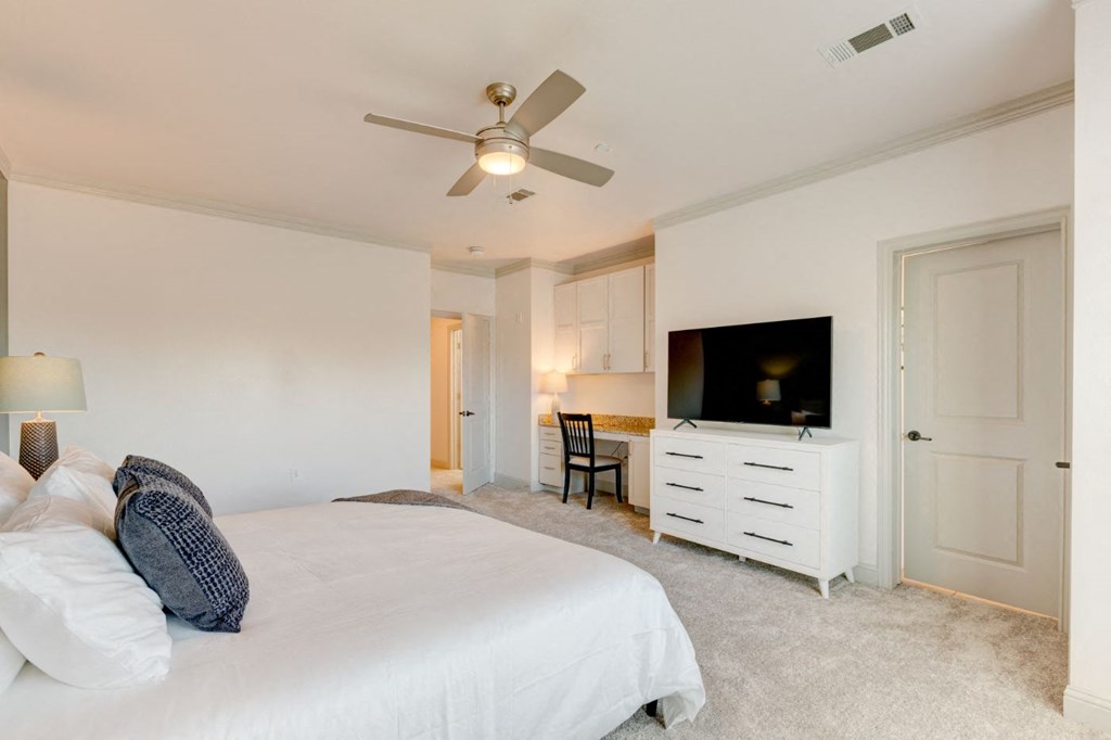 a bedroom with a bed and a ceiling fan