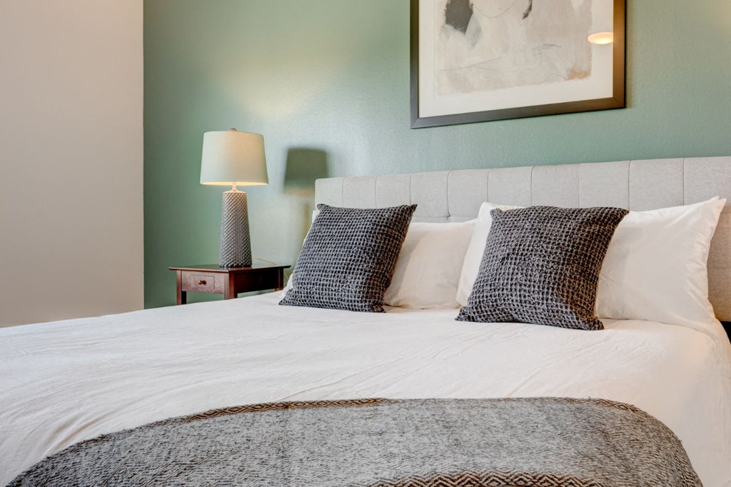 a bedroom with a white bed and pillows