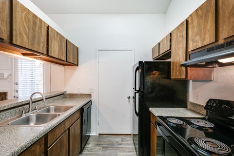 A kitchen with a black refrigerator and stove.