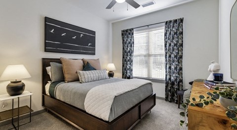 A bedroom with a large bed and a ceiling fan.