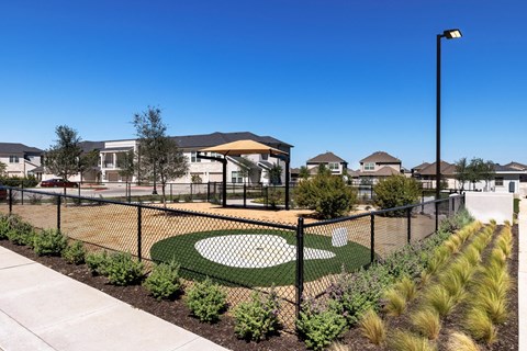 A park with a fence and a playground.