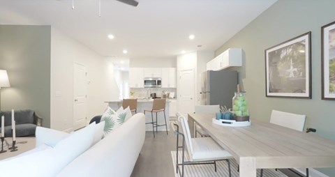 A modern living room with a white sofa and a wooden dining table.