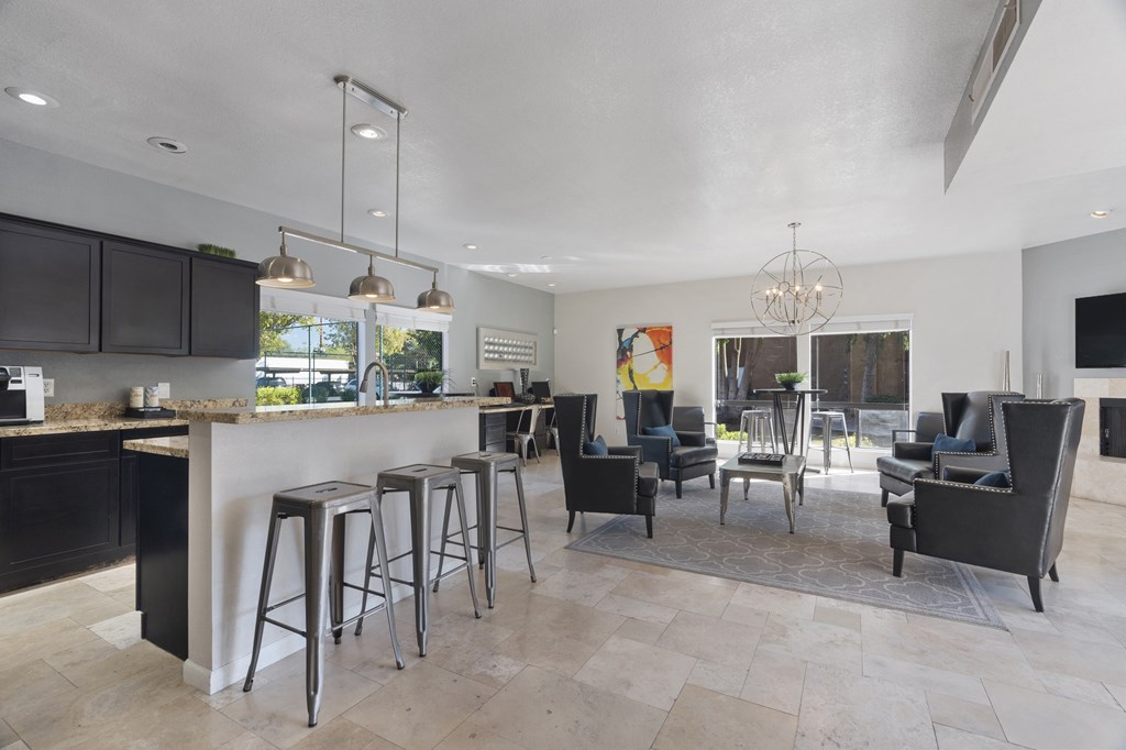 a kitchen with a bar and a living room with a table and chairs