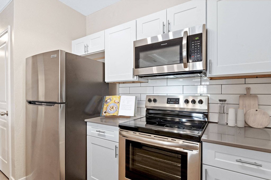 a kitchen with stainless steel appliances and white cabinets