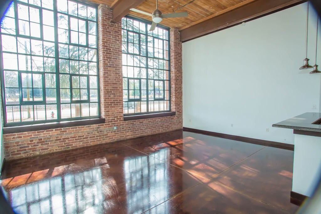A room with a large window and a ceiling fan.
