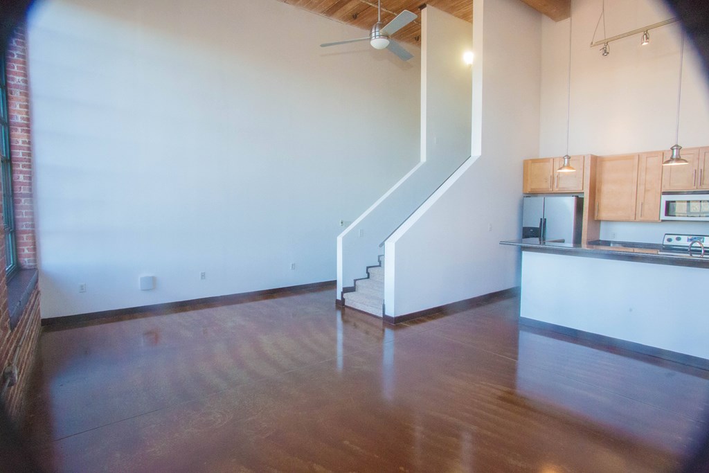 A room with a staircase and a kitchen area.