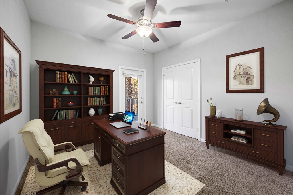 a home office with a desk and a ceiling fan
